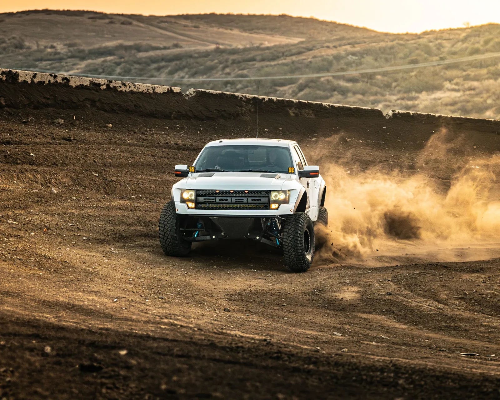 White Ford Raptor kicking up dust in the desert